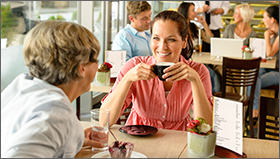 Mom and daughter in coffee shop having coffee.