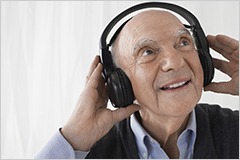 Elderly man listening to music with a headset on.