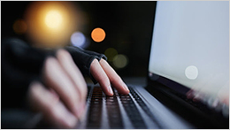 Scammer's hands on a keyboard.