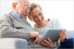 Happy father and daughter using digital tablet at home