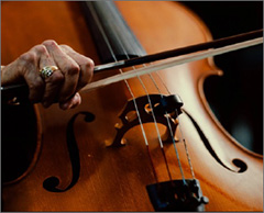 Close up of cello with hand holding a bow