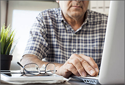 Elder man at work on laptop