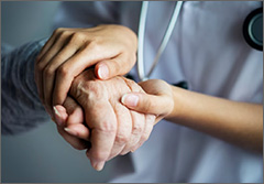 Attendant holding a patient's hand