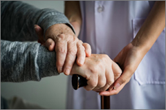 Elder mans hands with aid