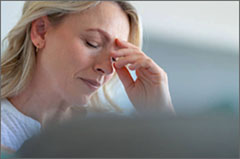 Woman holding her hand to her forehead