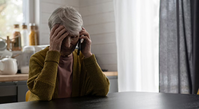 Elderly women on phone with hand to head