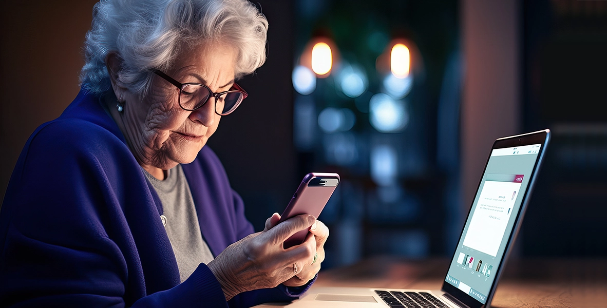Concerned grandmother with cell phone and laptop
