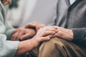 Woman comforting elderly man