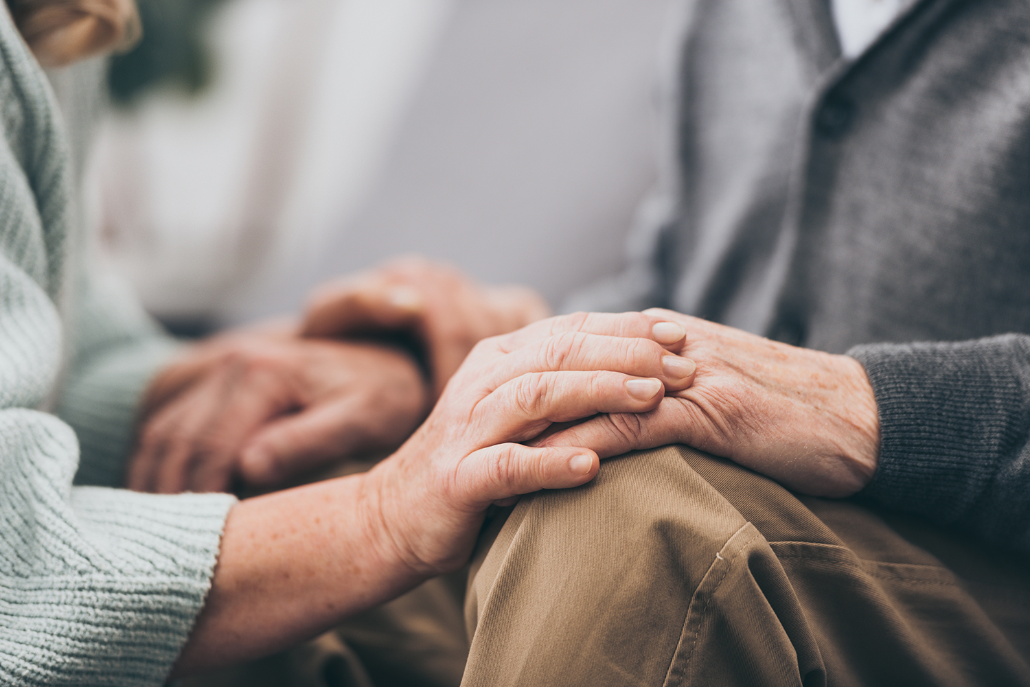 Woman comforting elderly man