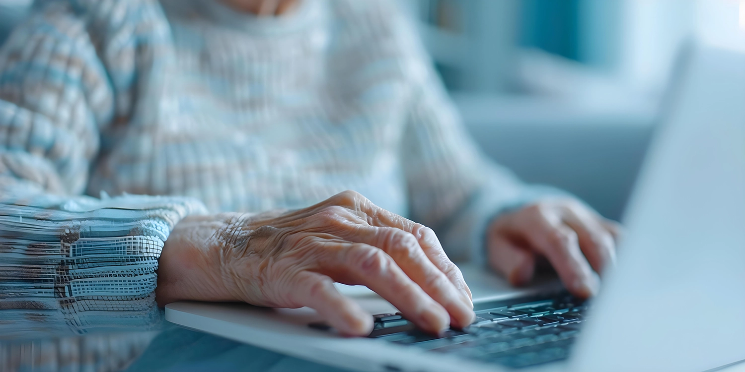 Elder woman with hands on laptop keyboard
